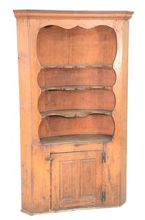 Corner Cupboard, having open top with scalloped shelves over raised panel door (new back), Connecticut circa 1780.
height 81 inches,...