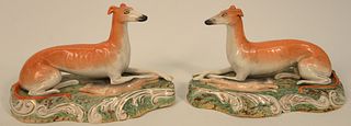 Pair of Staffordshire Whippet each molded as opposing recumbent figures beside hare.
height 6 1/2 inches, length 11 inches.