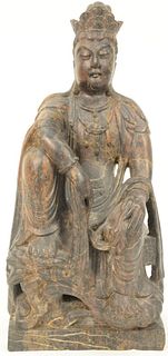 Large Chinese Carved Stone Guanyin wearing a robe and seated on base.
height 18 inches, width 8 1/2 inches.