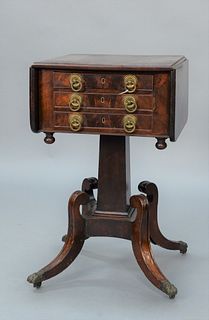 Duncan Phyfe Mahogany Drop Leaf Stand with three drawers on square supports all set on four downswept members ending in brass paw fe...