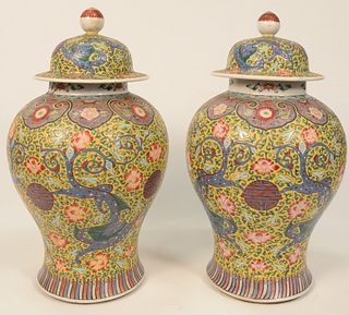 Pair of Famille Verte Covered Jars baluster form with painted blue dragons and yellow ground with green scrolling vines and wild flo...
