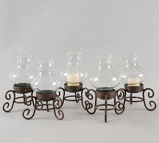 Lote de 5 candeleros. Siglo XX. Elaborados en hierro. Con pantallas de vidrio y soportes a manera de roleos.