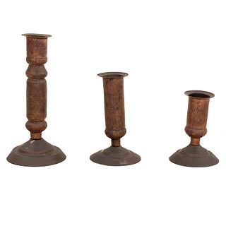 Lote de 3 candeleros. Siglo XX. Elaborados en cobre. Con arandelas circulares, fustes compuestos y soportes circulares.