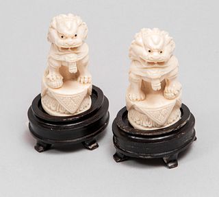 Par de leones de Fu. Origen oriental. Siglo XX. En talla de marfil con detalles en tinta negra y base de madera.