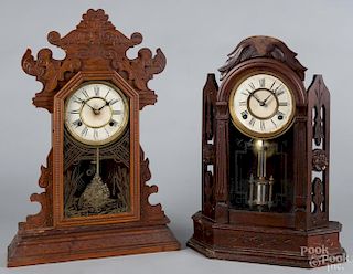 Two kitchen clocks, to include an oak Waterbury Clock Co., 22'' h., the other unmarked with a walnut