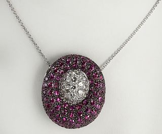 Lady's modern design round cut ruby, diamond and 18 karat white gold pendant necklace.