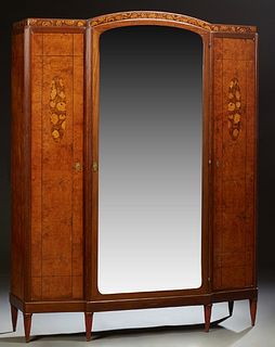 French Inlaid Walnut Armoire, c. 1930, the arched crest over an arched beveled mirror door, flanked by setback narrow doors, on a pl...