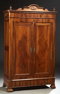 French Louis Philippe Carved Walnut Armoire, 19th c., the canted corner crown with an arched crest and turned finials, over double d...