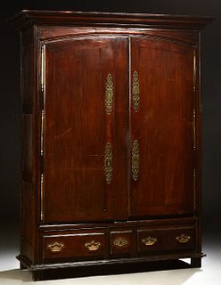 French Provincial Carved Oak Louis XVI Style Armoire, early 19th c., the stepped crown over arched double doors with brass fiche hin...