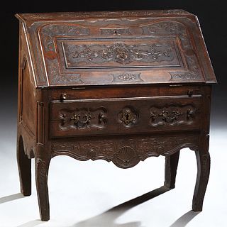 French Louis XV Style Carved Walnut Secretary, 19th c., the floral carved rectangular top over a figural carved slant lid opening to...
