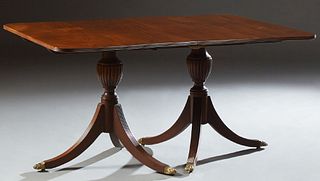 English Style Carved Mahogany Double Pedestal Dining Table, 20th c., the reeded edge rounded corner top on reeded urn supports to li...