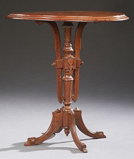 American Carved Walnut Eastlake Center Table, c. 1900, the oval stepped top on an incised turned support issuing four splayed reeded...