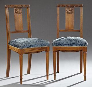 Pair of French Art Deco Carved Walnut Boudoir Chairs, early 20th c., the floral carved crest rails over a vertical splat above uphol...