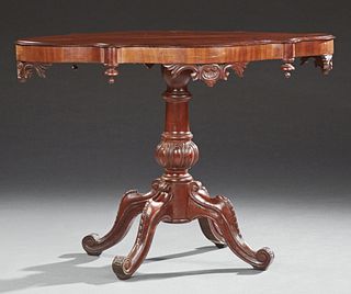 Continental Carved Mahogany Center Table, 19th c., the stepped tortoise shape top, on a tapered lobed pedestal with quadruped cabrio...
