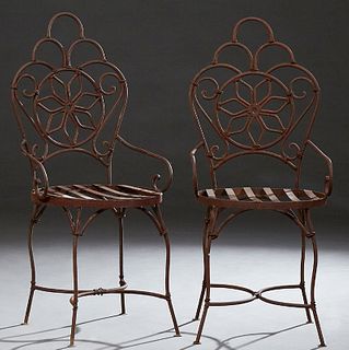 Pair of Cast Iron Victorian Style Patio Armchairs, 20th c., the arched backs with a central pierced flower, over scrolled arms to a...