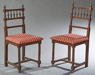 Pair of French Henri II Style Carved Walnut Bedroom Chairs, late 19th c., the spindled back over a trapezoidal seat, on turned taper...