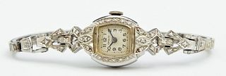 Lady's 14K White Gold Wristwatch, mid 20th c., by Crysler, with a diamond mounted bezel, lugs and links of the band, Gold Wt.- .46 t...