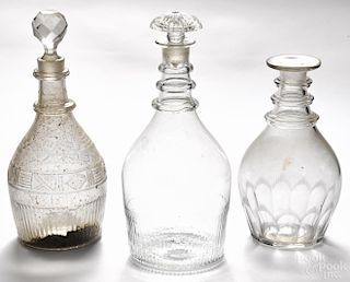 Three blown molded colorless glass decanters, 19th c., with applied rings and cut accents