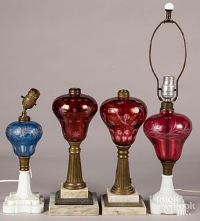 Four cut to clear glass fluid lamps.