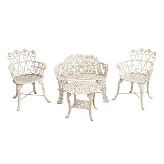 Sala para jardín. Siglo XX. Elaborada en hierro. Color blanco. Consta de: Mesa de centro, loveseat y par de sillones. Piezas: 4.