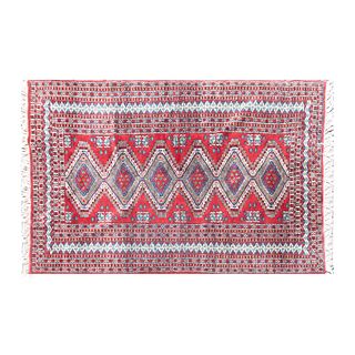 Tapete. Siglo XX. Estilo Boukhara. Elaborado en fibras de lana y algodón. Decorado con elementos geométricos y florales. 193 x 125 cm