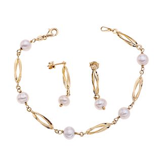 Pulsera y par de aretes con perlas en oro amarillo de 14k. 7 perlas cultivadas color blanco de 7 mm. Peso: 6.8 g.