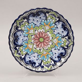 Plato decorativo. Puebla, México. Siglo XX. Elaborado en cerámica vidriada. Pintado a mano. Decorado con elementos florales.