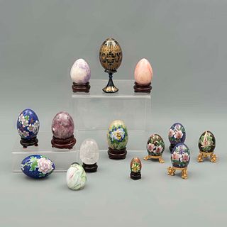Lote de 14 huevos decorativos. Siglo XX. En cloisonné, madera policromada, vidrio y piedra. Diferentes tamaños. Algunos con bases.