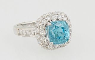 Lady's 14K White Gold Dinner Ring, with a cushion cut 6.38 ct. blue zircon atop a double graduated concentric border of round diamonds, the shoulders 