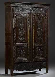 French Provincial Carved Oak Louis XV Style Armoire, 19th c., probably Brittany, the carved corner crown over arched three panel double doors with flo