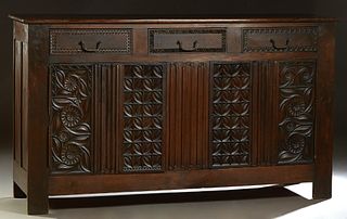 Spanish Renaissance Style Carved Oak Sideboard, late 19th c., the rectangular two board top over two large carved cupboard doors with iron fiche hinge