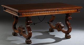 Spanish Carved Beech Dining Table, 20th c., the stepped gadrooned edge top over a wide carved skirt, on trestle supports with paw feet, joined by wrou