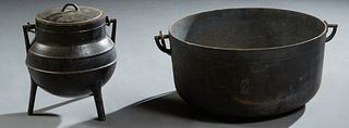 Two French Provincial Cast iron Cauldrons, 19th c, with folding iron handles, the smaller one lidded, Larger- H.- 8 1/4 in., W.- 20 in., D.- 17 in. (2
