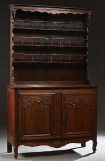 French Provincial Louis XV Style Carved Oak Vaisselier, 19th c., the stepped crown over three spindled plate racks on a rounded corner base with two f