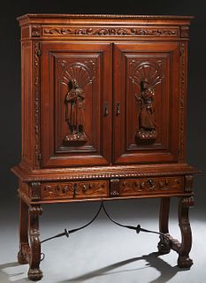 Spanish Medieval Style Carved Beech Silver Cabinet. 20th c., the gadroon edge crown over double doors with figural relief carving, over a shelved inte