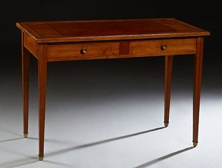French Louis XVI Style Carved Cherry Writing Table, early 20th c., the inset gilt tooled leather top over two frieze drawers, on tapered square legs, 