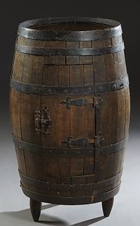 French Provincial Carved Beech Barrel Bar, 20th c., with iron banding, and double doors on the sides, on turned tripodal legs, H.- 34 1/2 in., Dia.- 2