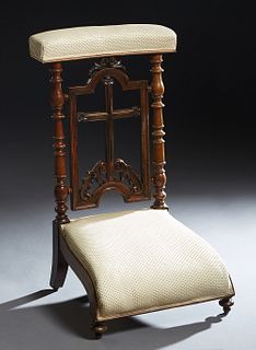 French Carved Walnut Prie Dieu, c. 1870, the upholstered arm rest over a cruciform back splat, to a curved kneeler on turned legs, in beige upholstery