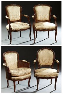 Assembled Set of Four French Louis XV Style Fauteuils, early 20th c., consisting of a pair of floral carved examples with shield backs over upholstere