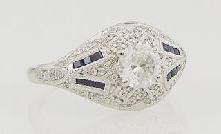 Lady's Platinum Dinner Ring, with a central .71 ct. round diamond, flanked by tapering diamond mounted shoulders inset with four bands of baguette blu
