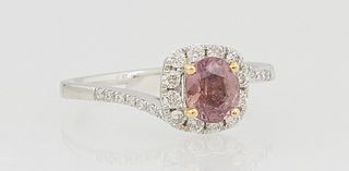 Lady's Platinum Dinner Ring, with a 1.05 Padparadscha pink sapphire, atop a border of round diamonds, on a bypass band with diamond mounted shoulders,