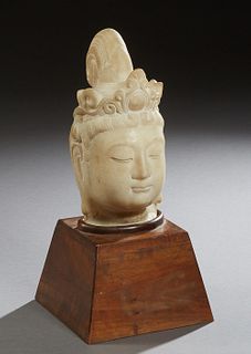 Carved Marble Head of Buddha, 19th c. or earlier, presented on a sloping mahogany plinth, Head- H.- 10 3/4 in., W.- 5 1/2 in., D.- 6 1/4 in., Plinth- 