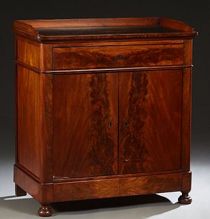 Diminutive Louis Philippe Style Carved Mahogany Sideboard, 19th c., the rounded corner 3/4 galleried top with an inset oil cloth writing surface, over