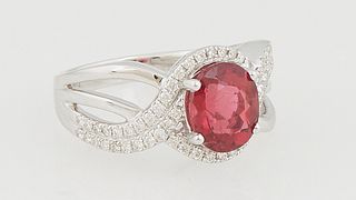 Lady's 14K White Gold Dinner Ring, with an oval 2.06 ct. rubelite atop a diamond mounted border, on a split diamond mounted band, total diamond wt.- .