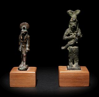An Egyptian Bronze Anubis and an Egyptian Bronze Isis and Horus
Height of taller example 3 1/8 inches; height of shorter example 2 1/2 inches.