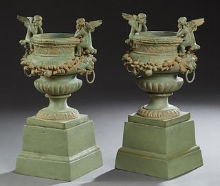 Pair of Green Patinated Bronze Figural Planters, 20th/21st c., with two winged putto on the rim of a campana form urn, above a relief floral band, on 