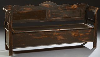 French Provincial Carved Pine Settle, 19th c., the peaked scrolling back to curved arms, flanking a lifting lid above open storage, on block feet, H.-