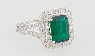 Lady's Platinum Dinner Ring, with a 2.11 ct. emerald, atop a double concentric graduated border of tiny round diamond, total diamond wt.- .58 cts., si