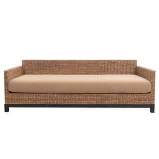 Sofá de 3 plazas. Siglo XX. Elaborado en mimbre tejido. Con respaldo cerrado y asiento acojinado en tapicería color marrón.