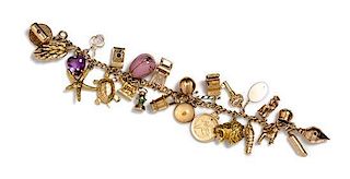 A 14 Karat Yellow Gold Charm Bracelet with 25 Attached Charms, 42.60 dwts.